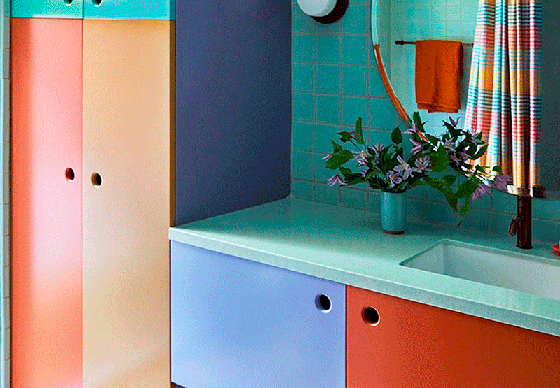 Mueble de baño colorido y alegre con puertas naranja, azul, amarillo y verde.